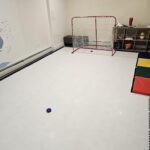 Practice hockey on synthetic ice rink installed in a finished basement.