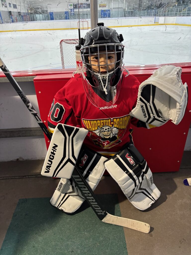 Young hockey goalie in full gear practicing saves on a synthetic ice rink by Skate Anytime.