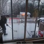 Hockey player practicing drills on synthetic ice outdoors in snowy winter conditions.